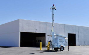 OnView Mobile Surveillance Trailer with an elevated camera mast deployed outside a commercial building.