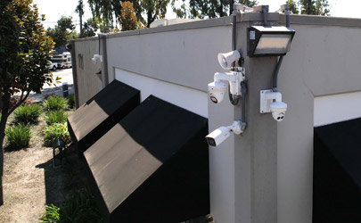 Commercial security cameras, audio deterrent equipment, and lighting installed on the exterior of a property.