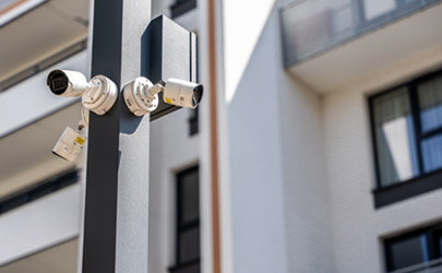 Commercial security cameras and audio deterrent speaker mounted on the exterior of a building.